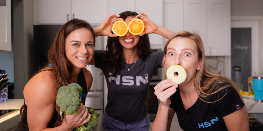 nutriton coaches being funny standing around putting veggies and fruits over their eyes and mouths