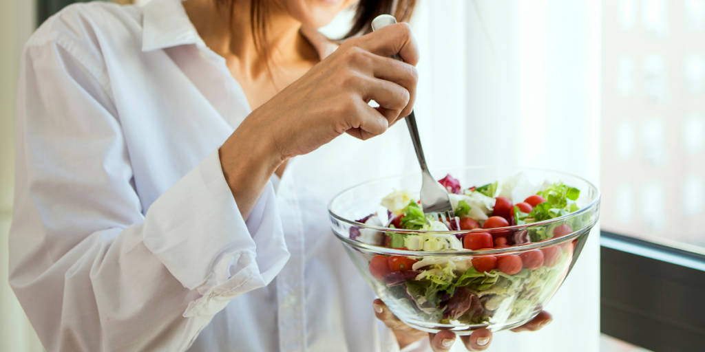 a woman eating mindfully a salad showing healthy eating habits