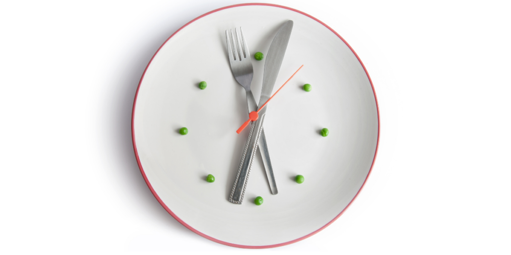 a clock with a fork and knife demonstrating when to eat pre workout foods