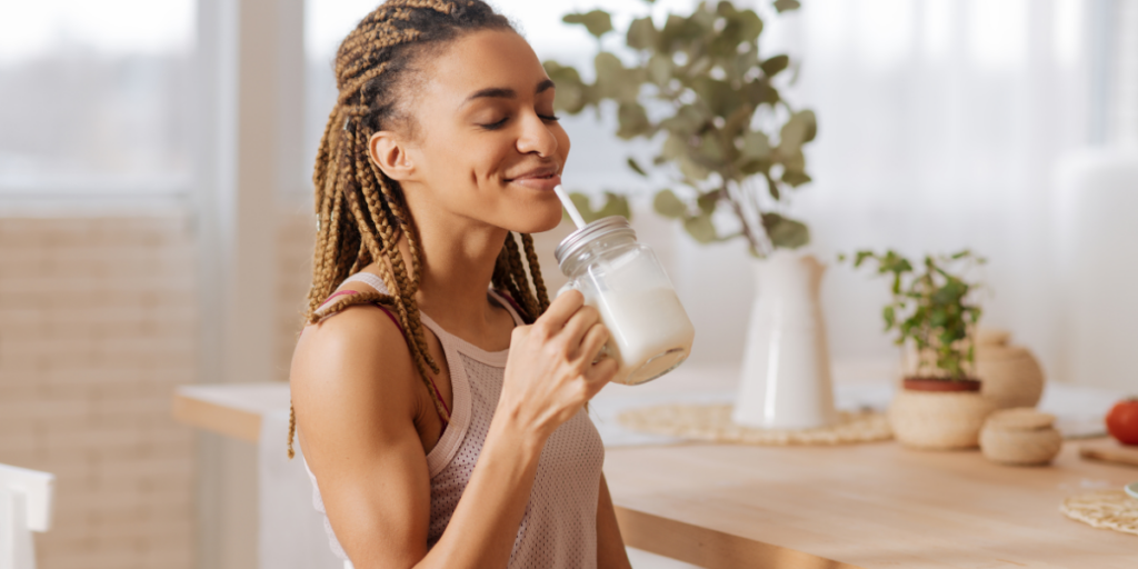 woman drinking a shake as pre workout foods