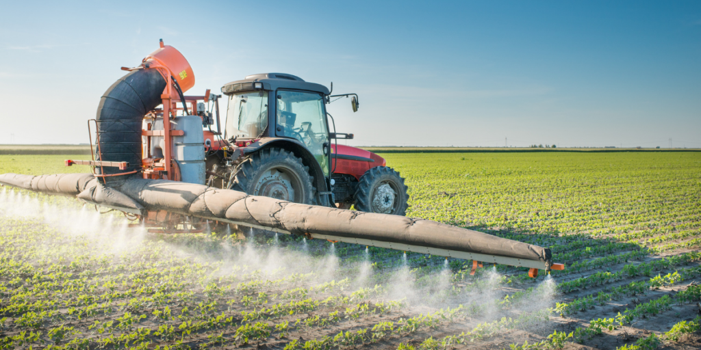 farmer spraying field with pesticides that contain hormone distruptors